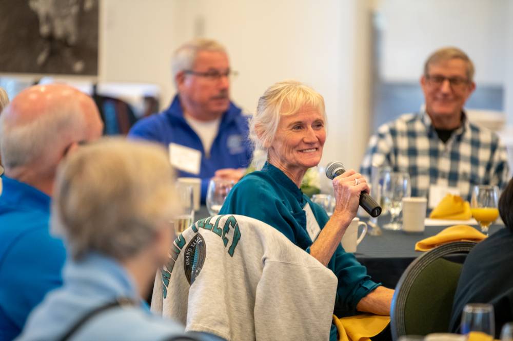 An alumna speaking to the audience.